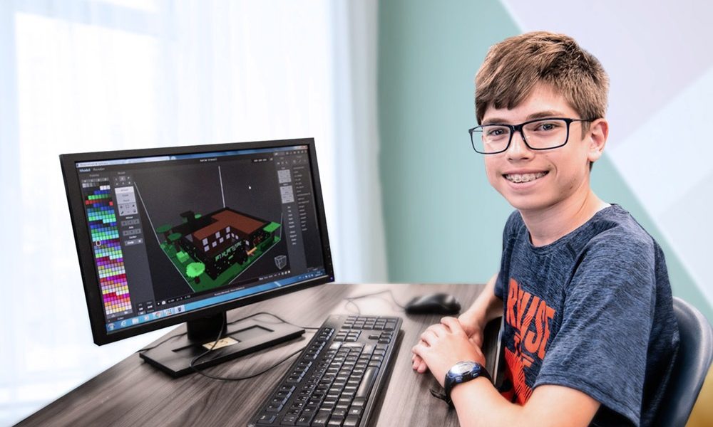 Un enfant montrant son code informatique sur son ordinateur